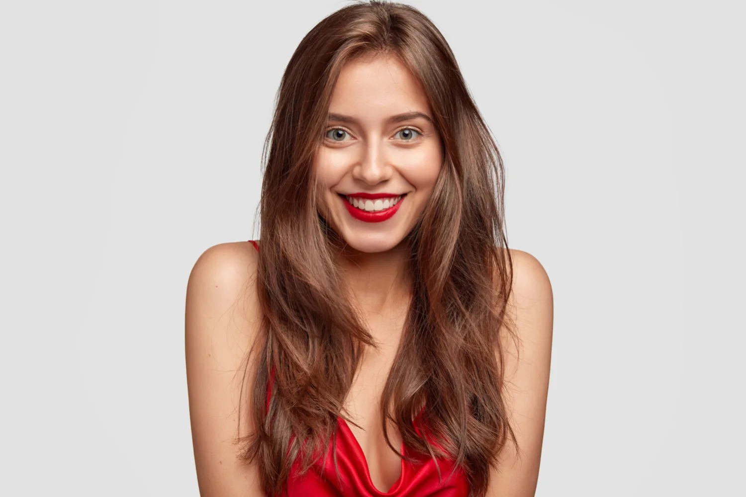 beauty-fashion-makeup-people-concept-lovely-happy-woman-with-red-lipstick-shows-white-perfect-teeth-has-healthy-skin-long-dark-hair-isolated-white-wall-expresses-happiness.jpg